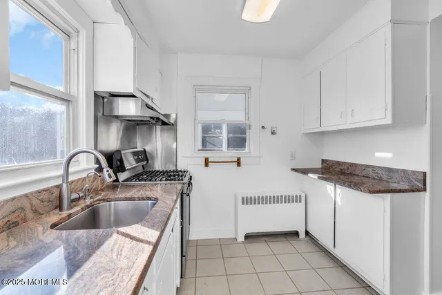 a kitchen with stainless steel appliances granite countertop a sink stove and cabinets