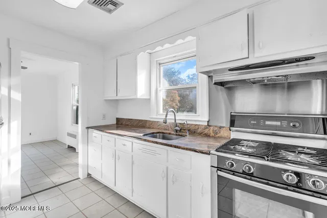 a kitchen with granite countertop a sink and a stove