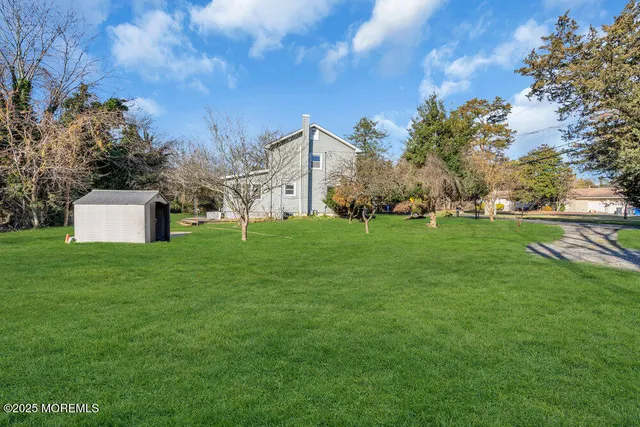a backyard of a house with lots of green space and fountain