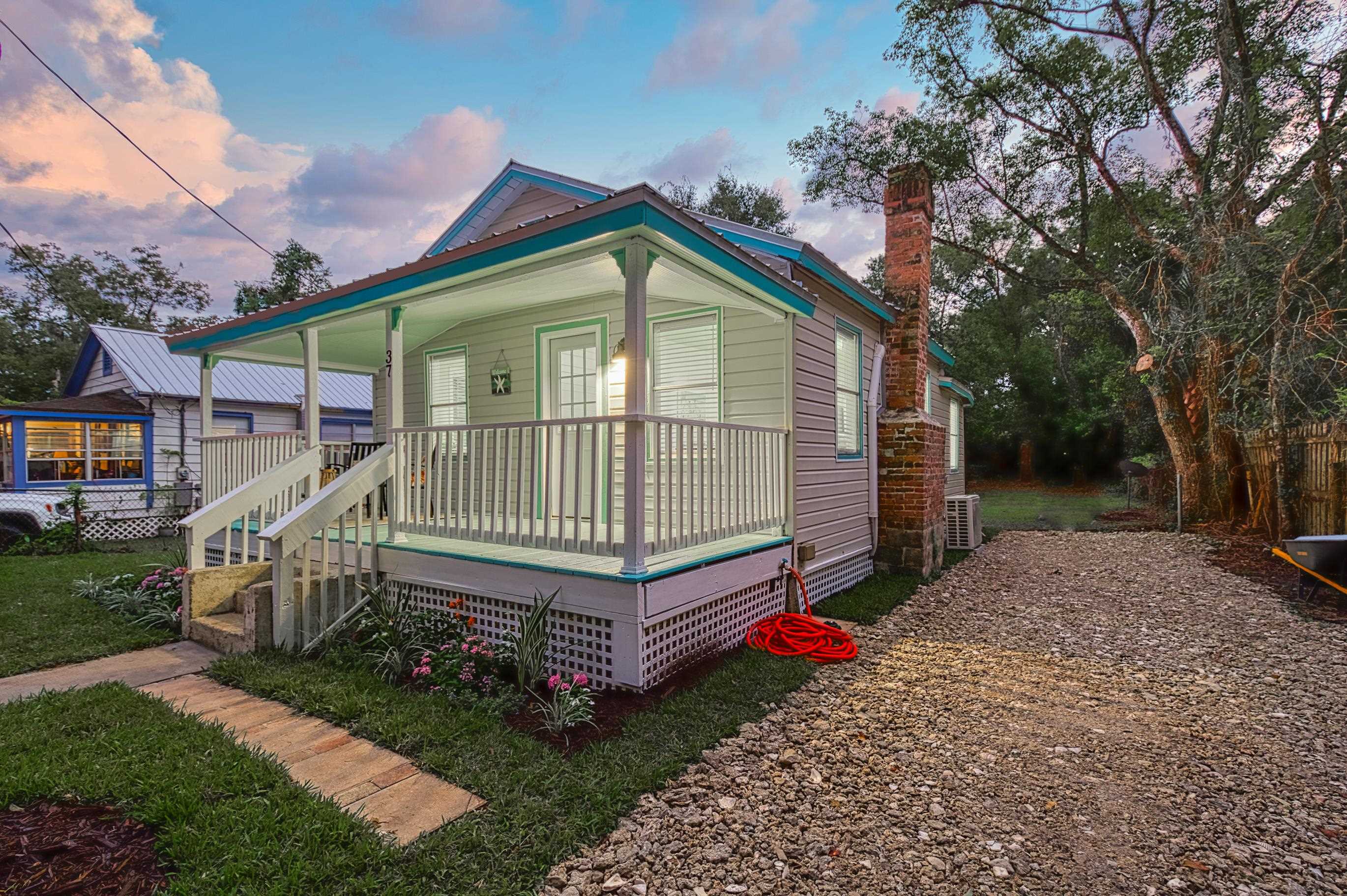 a front view of a house with a yard and deck