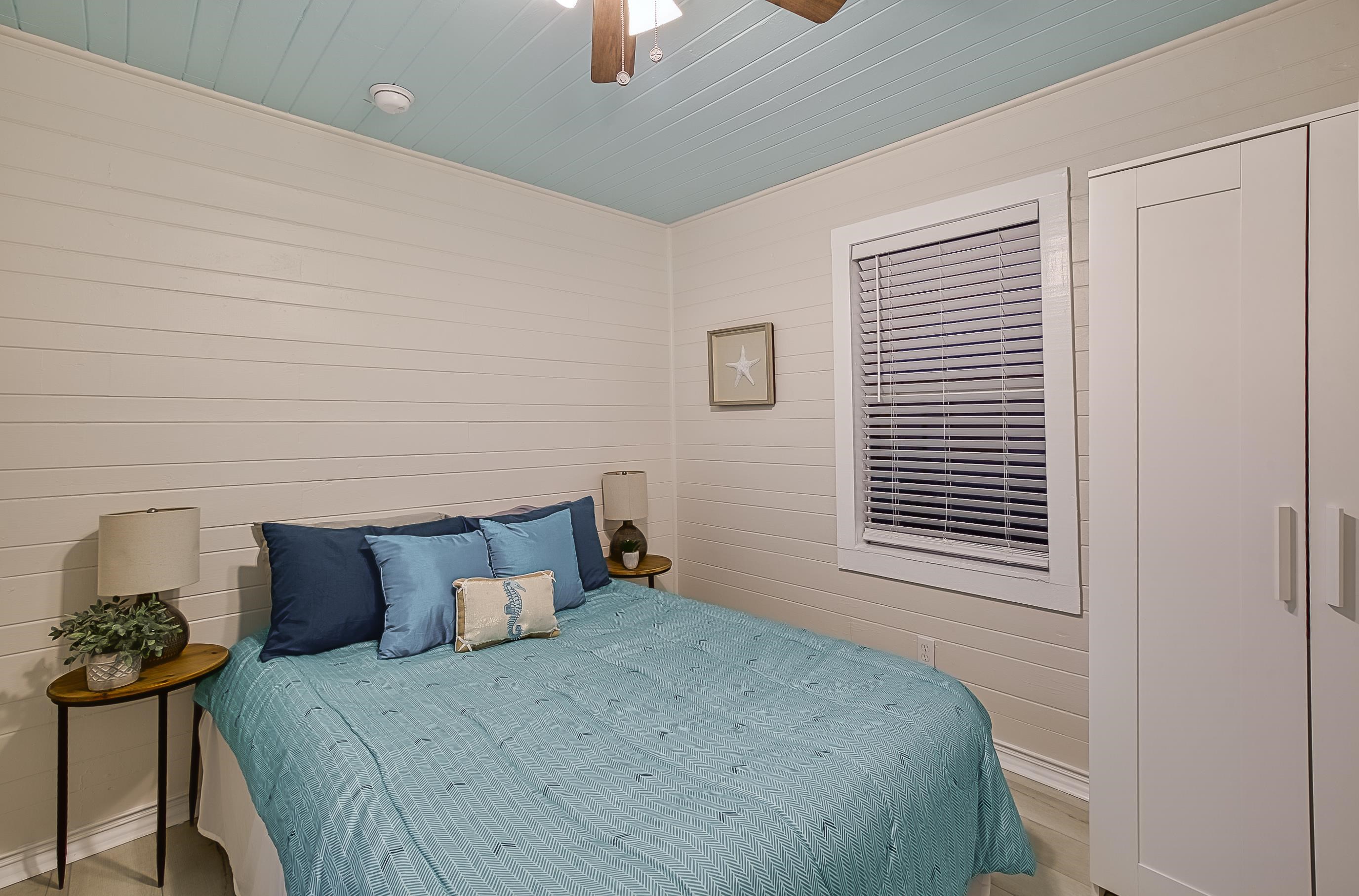 37 Phillips Street St. Augustine, FL 32084 - Photo 13 of 26 a bed sitting in a bedroom next to a window and a chandelier