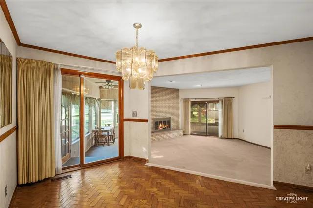 a view of an empty room with glass door and windows