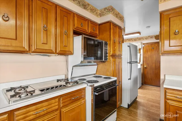 a kitchen with stainless steel appliances granite countertop a stove and a refrigerator