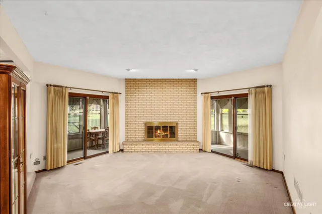 an empty room with fireplace and windows