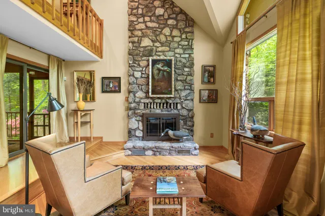 a living room with furniture a flat screen tv and floor to ceiling window