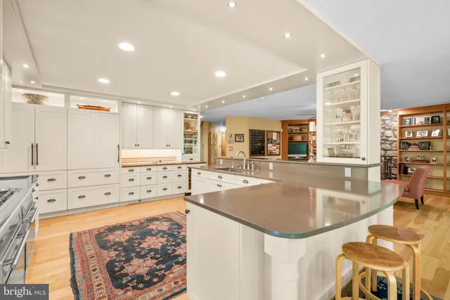 a living room with furniture kitchen view and a wooden floor