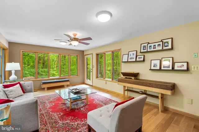 a living room with fireplace furniture and a large window