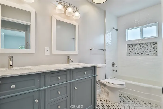 a bathroom with a granite countertop toilet sink and mirror