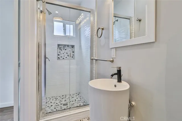 a bathroom with a sink a mirror and a shower