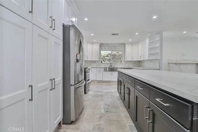 a kitchen with stainless steel appliances granite countertop a refrigerator and a sink