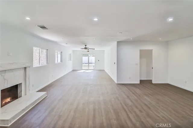 a view of a livingroom with wooden floor and a fireplace