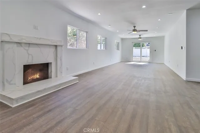 a view of an empty room with a fireplace and a window