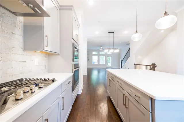 a view of a kitchen with wooden floor and windows