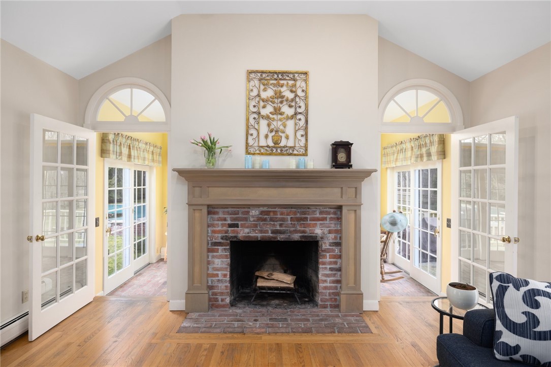 2 Lansdowne Road Warwick, RI 02888 - Photo 15 of 49 A wood burning, brick fireplace is the centerpiece of this room. Glass doors lead to the sunroom on either side and bathe the room in natural light.