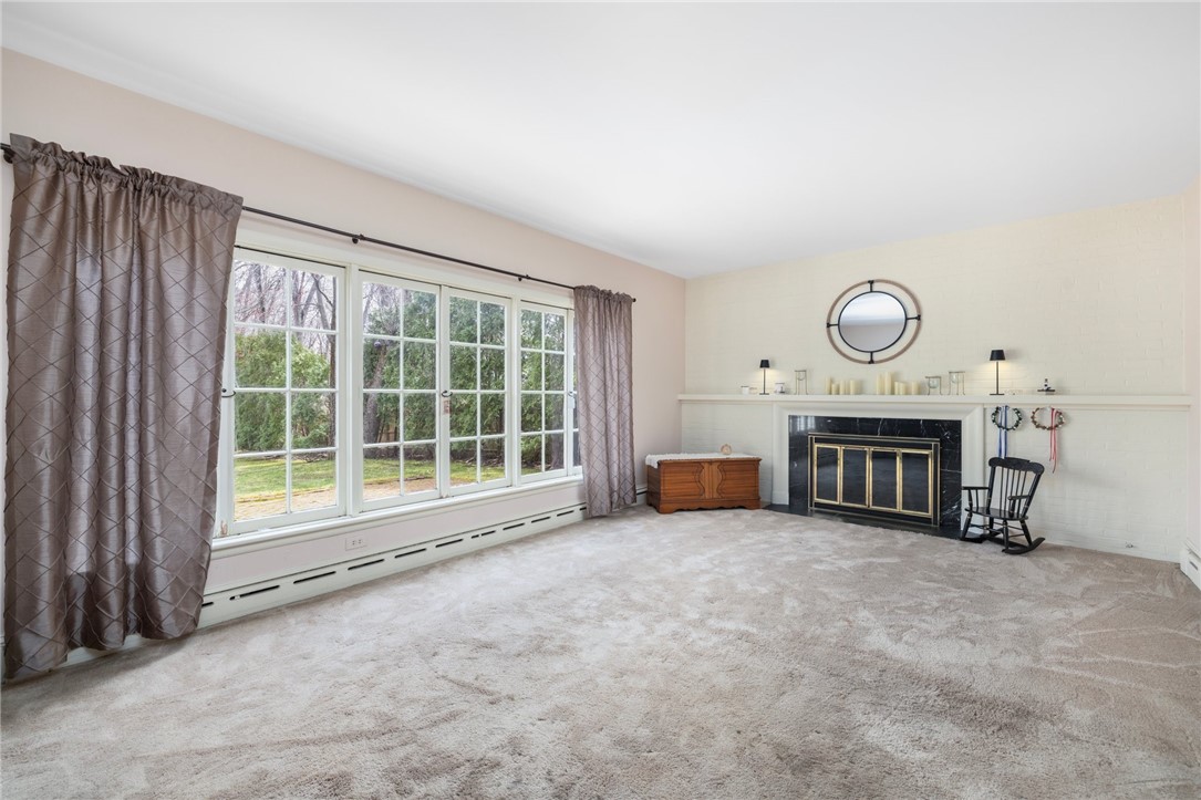 2 Lansdowne Road Warwick, RI 02888 - Photo 21 of 49 The formal living room is an amazing space with a wood burning fireplace and a bank of windows that looks out to the backyard. It also offers a door that leads directly to the backyard.