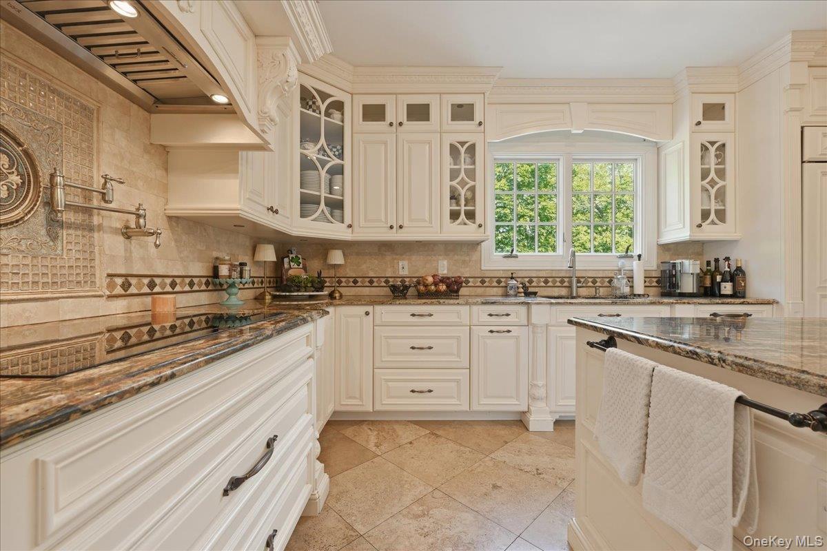 31 Cornwall Lane Sands Point, NY 11050 - Photo 19 of 49 a kitchen with granite countertop white cabinets white appliances a sink and a window