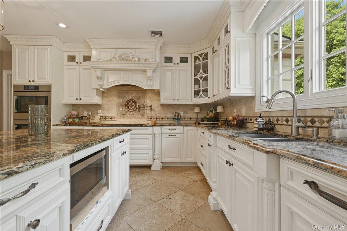 31 Cornwall Lane Sands Point, NY 11050 - Photo 20 of 49 a kitchen with granite countertop a sink stove and cabinets