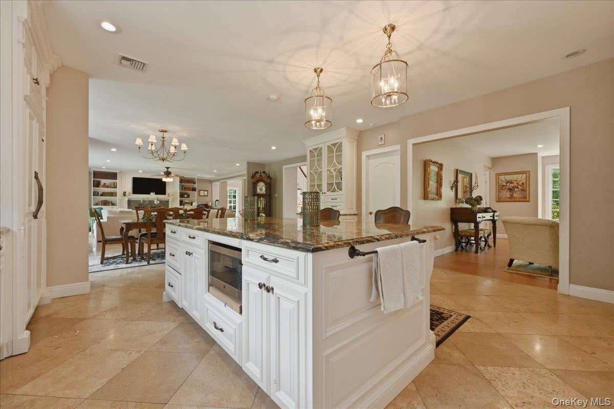 31 Cornwall Lane Sands Point, NY 11050 - Photo 21 of 49 a large white kitchen with lots of counter space dining table and stainless steel appliances