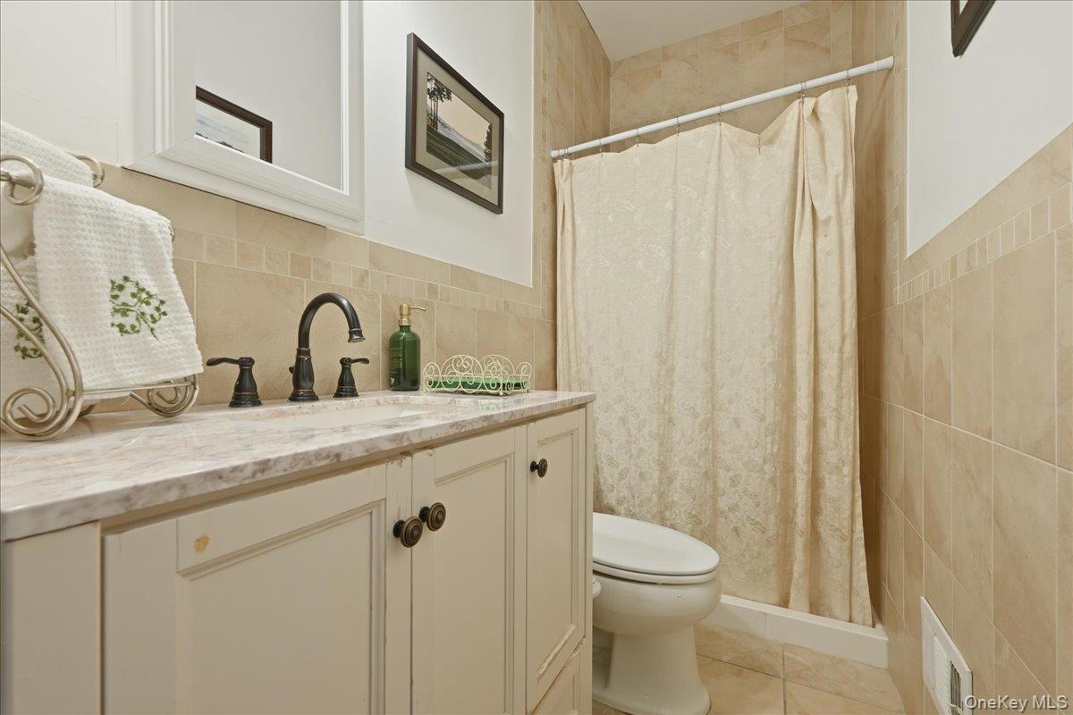 31 Cornwall Lane Sands Point, NY 11050 - Photo 25 of 49 a bathroom with a granite countertop sink toilet and shower