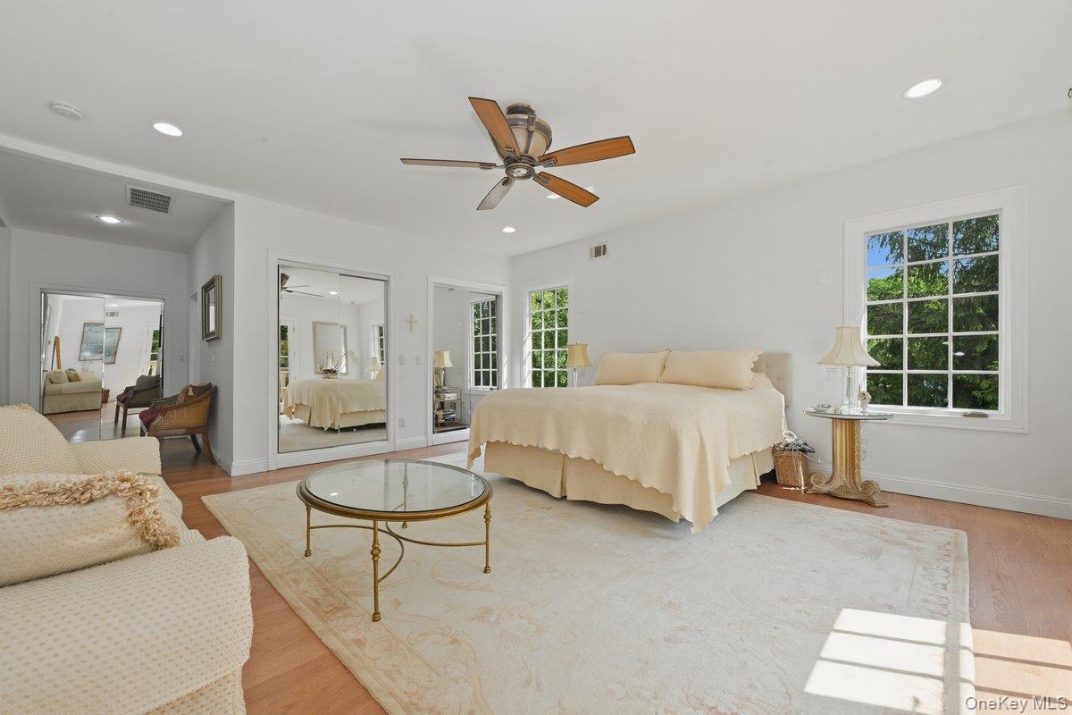 31 Cornwall Lane Sands Point, NY 11050 - Photo 29 of 49 a spacious bedroom with a bed a couch and a window