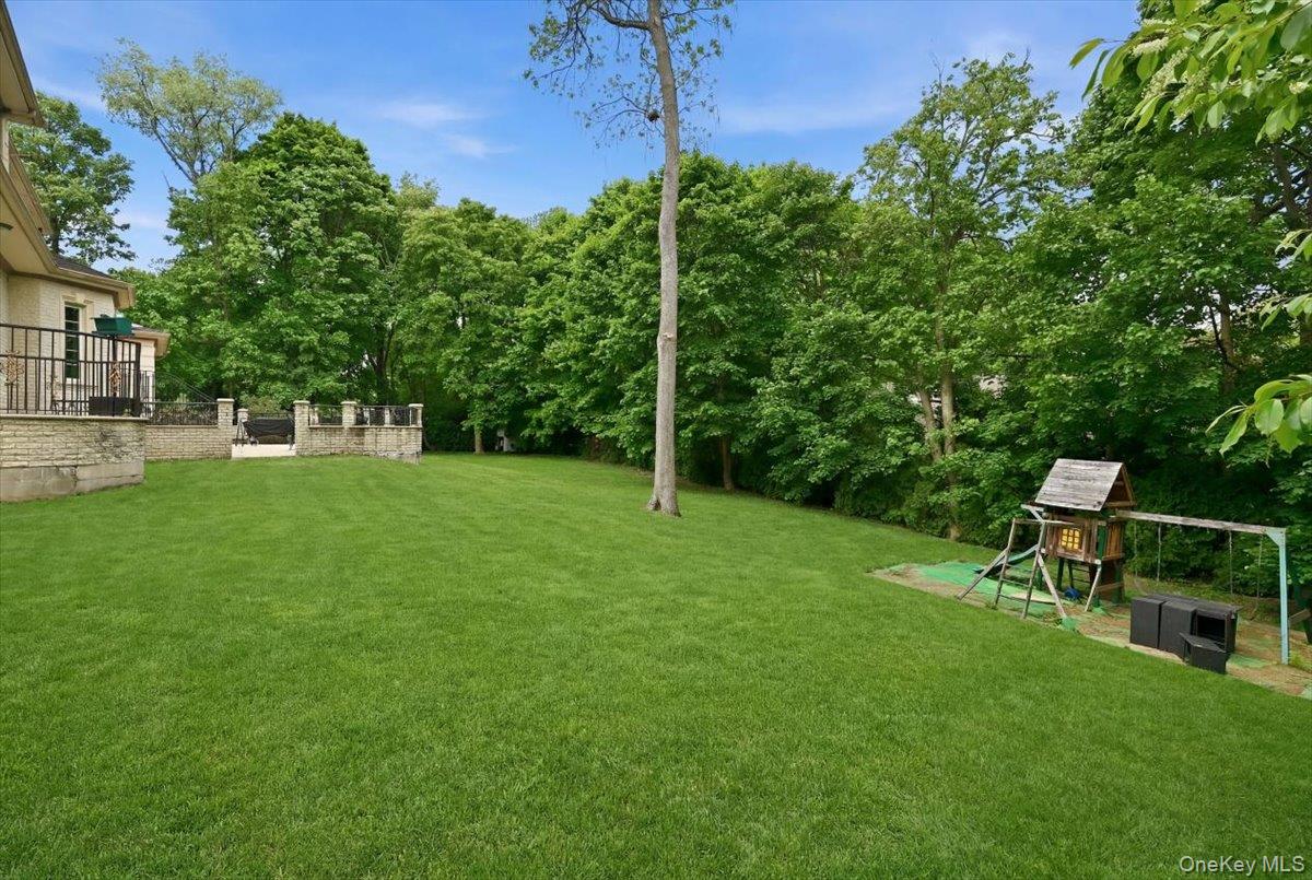 31 Cornwall Lane Sands Point, NY 11050 - Photo 37 of 49 a view of a backyard with table and chairs and wooden fence