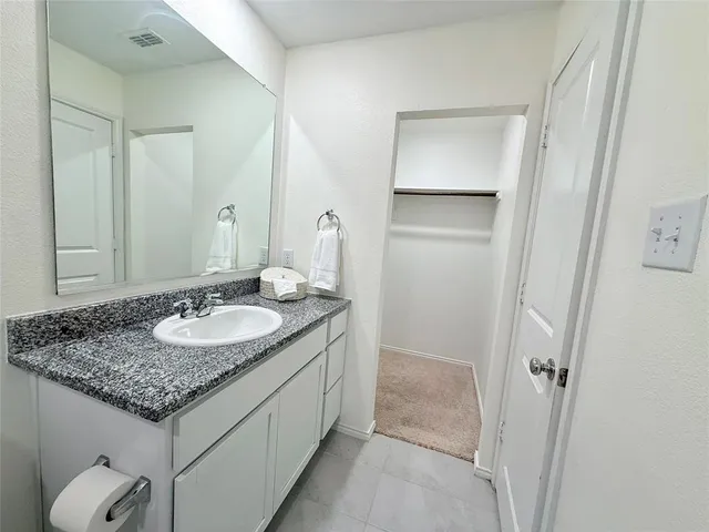 a bathroom with a granite countertop sink and a mirror