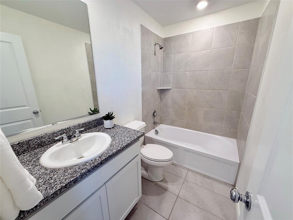 201 Boxberry Way Princeton, TX 75407 - Photo 14 of 24 a bathroom with a granite countertop sink toilet and shower