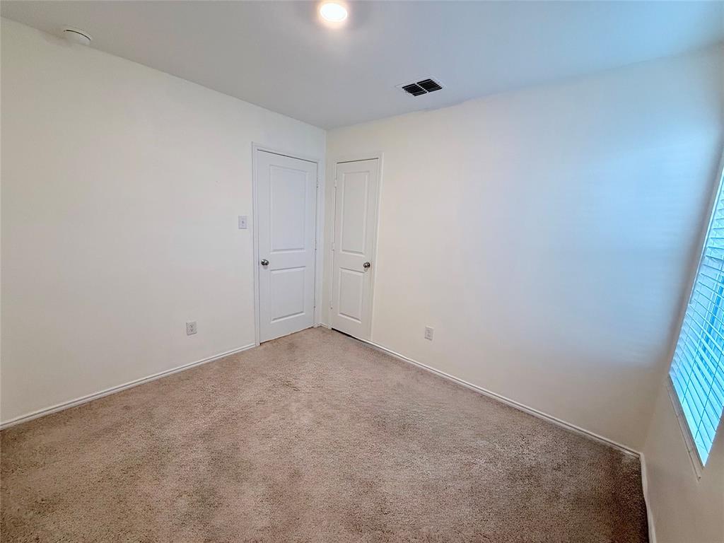 201 Boxberry Way Princeton, TX 75407 - Photo 17 of 24 Comfortable secondary bedroom with plush carpeting, neutral tones, and a window that brings in natural light. The room includes a closet for convenient storage and offers a versatile space ideal for a bedroom, home office, or guest room.