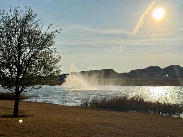 a view of swimming pool with lawn chairs and lake view