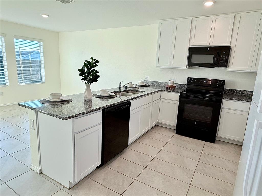 201 Boxberry Way Princeton, TX 75407 - Photo 3 of 24 a kitchen with a sink and a stove top oven