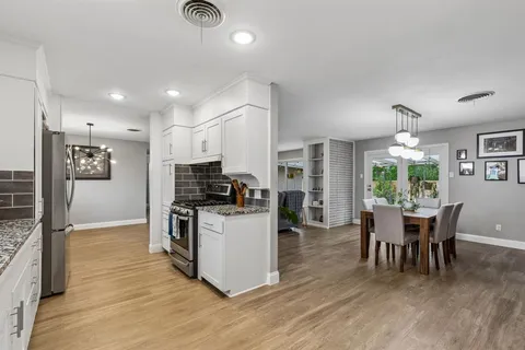 a kitchen with a table chairs refrigerator and cabinets