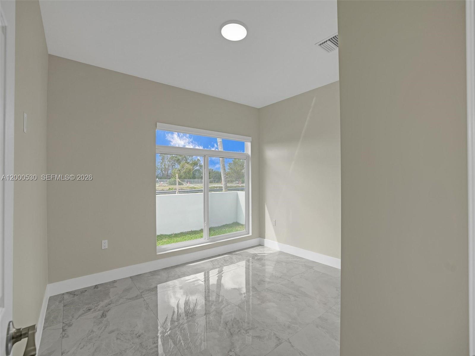 14519 Southwest 272nd Street, Unit 14519 Homestead, FL 33032 - Photo 11 of 32 an empty room with windows