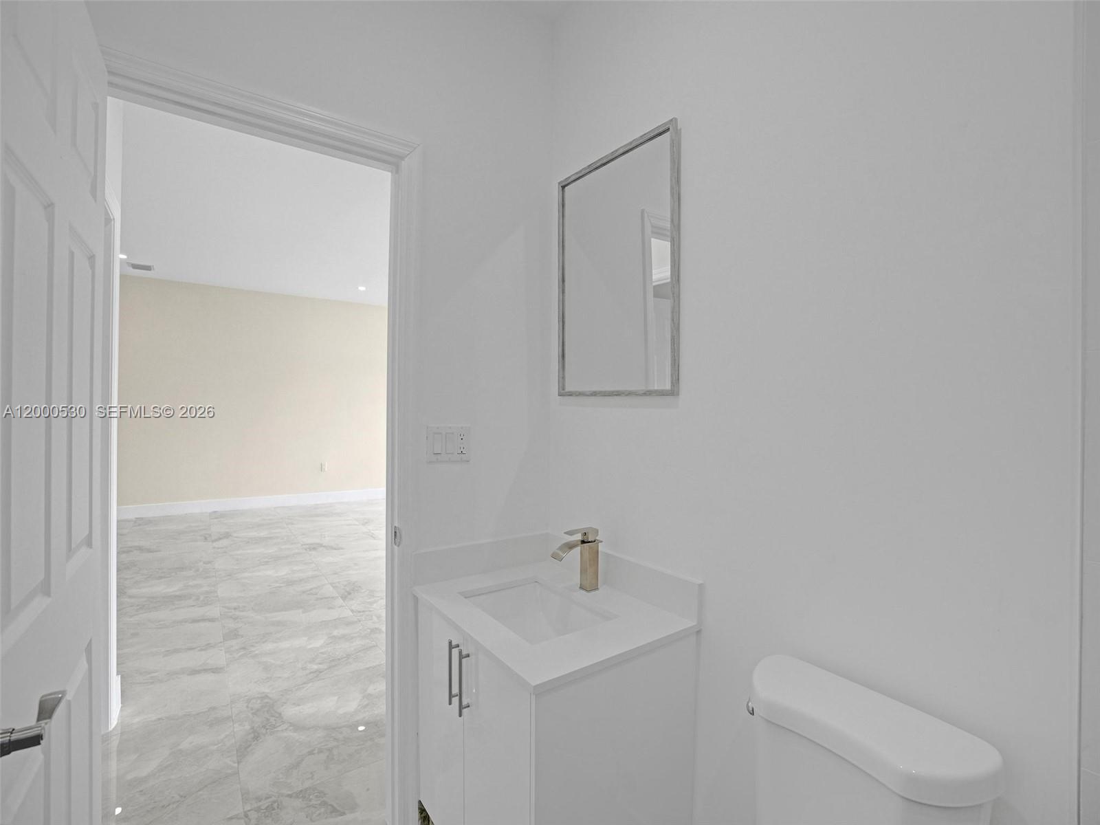 14519 Southwest 272nd Street, Unit 14519 Homestead, FL 33032 - Photo 16 of 32 a bathroom with a toilet sink vanity and mirror