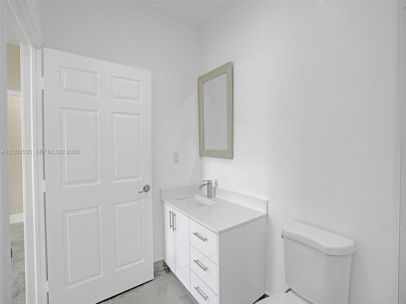 14519 Southwest 272nd Street, Unit 14519 Homestead, FL 33032 - Photo 26 of 32 a bathroom with a sink a toilet and a mirror