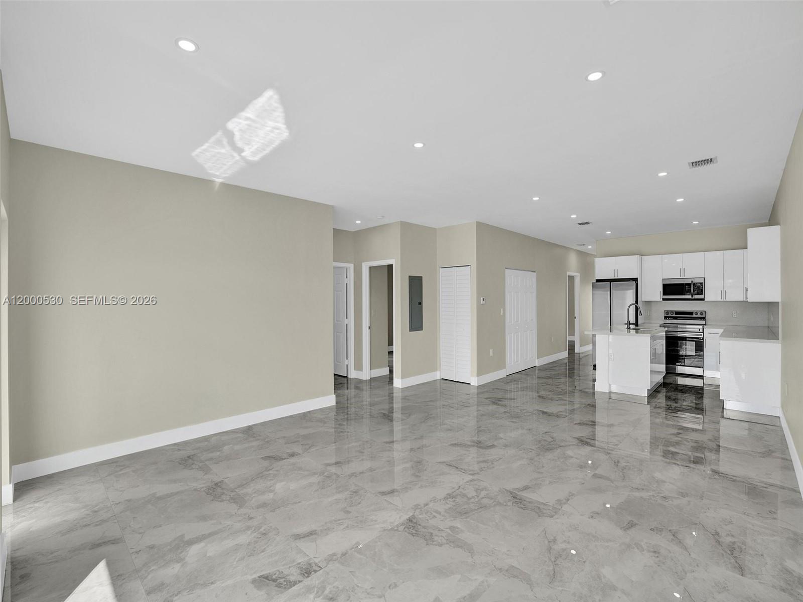 14519 Southwest 272nd Street, Unit 14519 Homestead, FL 33032 - Photo 3 of 32 an empty room with kitchen view and windows