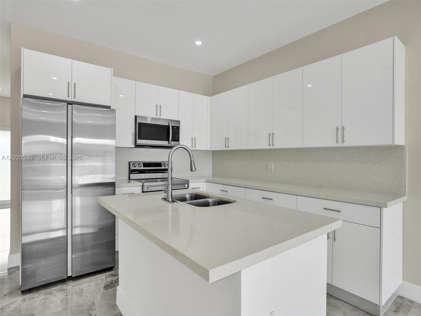 14519 Southwest 272nd Street, Unit 14519 Homestead, FL 33032 - Photo 9 of 32 a kitchen with a refrigerator a microwave and sink