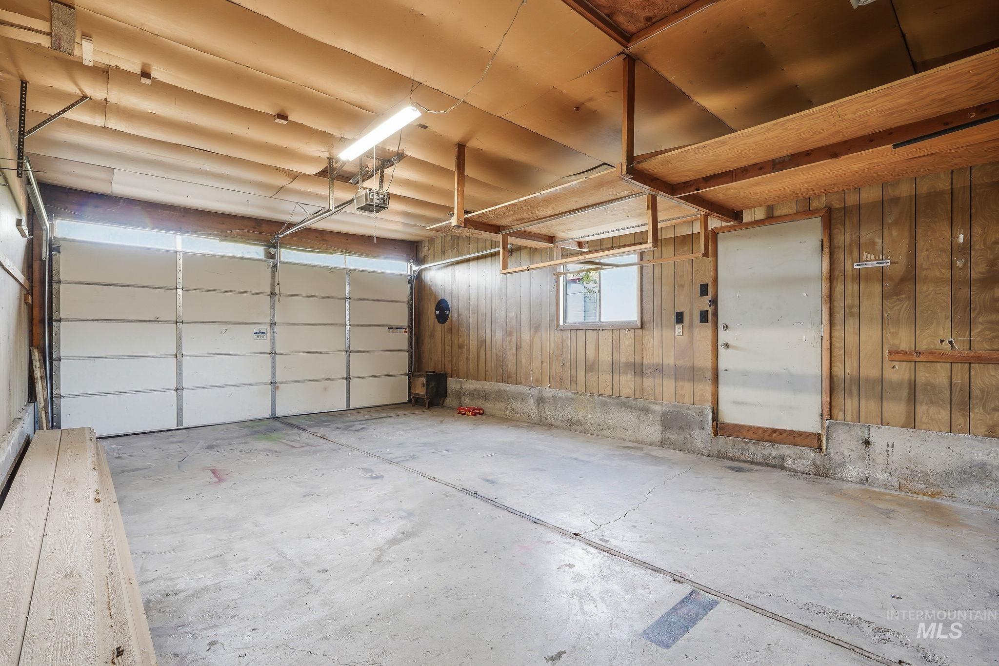 1990 Panama Street Boise, ID 83705 - Photo 42 of 50 Spacious garage featuring a concrete floor, wood-paneled walls, and a white sectional garage door