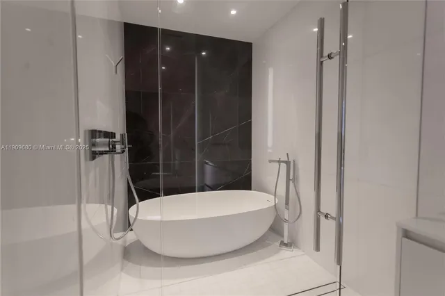 a bathroom with a glass door shower a sink and a mirror