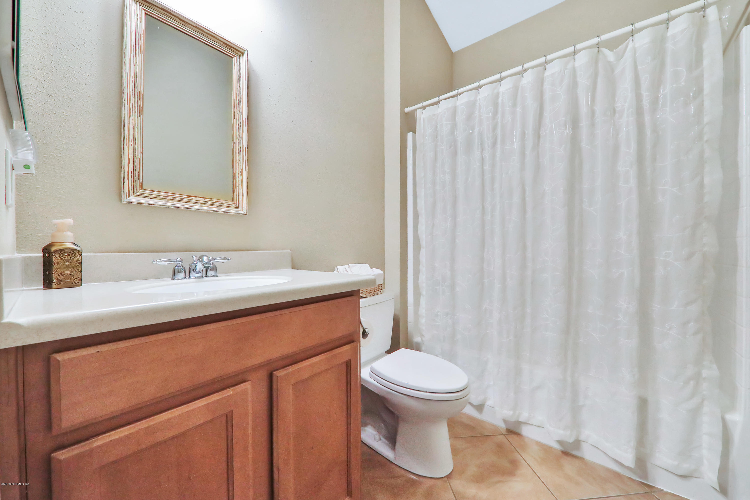 3417 South Saxxon Road St. Augustine, FL 32092 - Photo 22 of 47 a bathroom with a sink a toilet and shower curtain