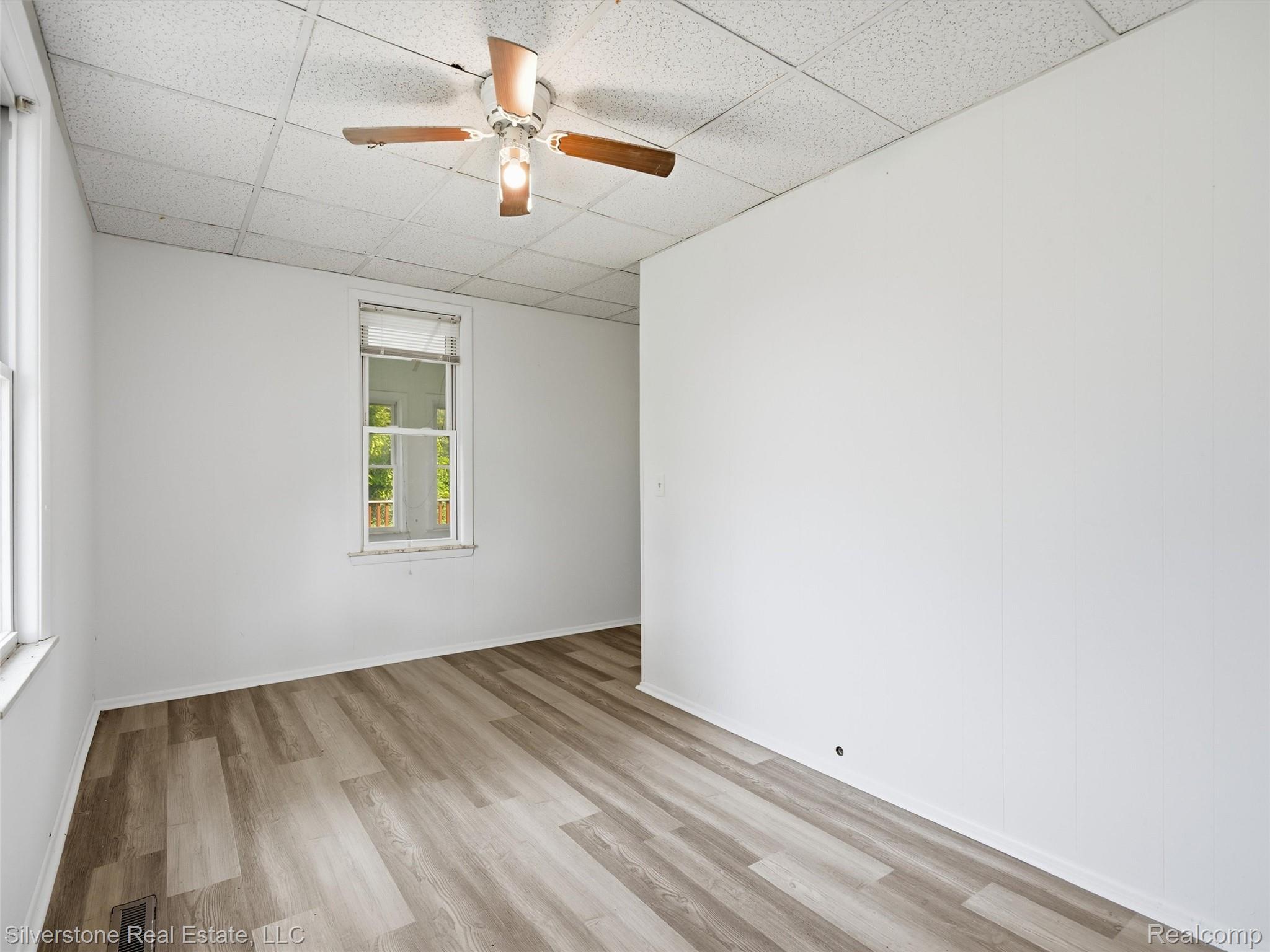 9691 Grames Road Maybee, MI 48159 - Photo 18 of 44 Wood-finish flooring, white walls, and a ceiling fan with integrated lighting