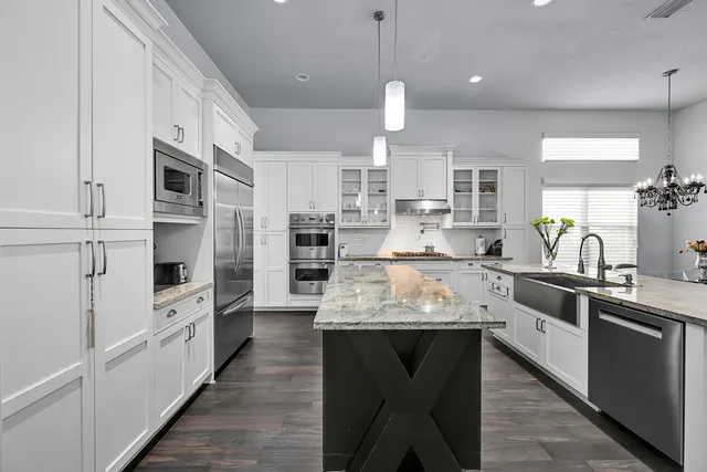 a kitchen with stainless steel appliances granite countertop a sink stove and refrigerator