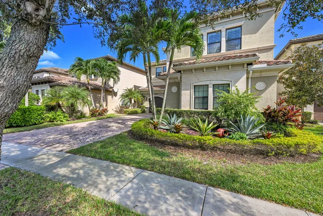 a front view of a house with a yard and potted plants