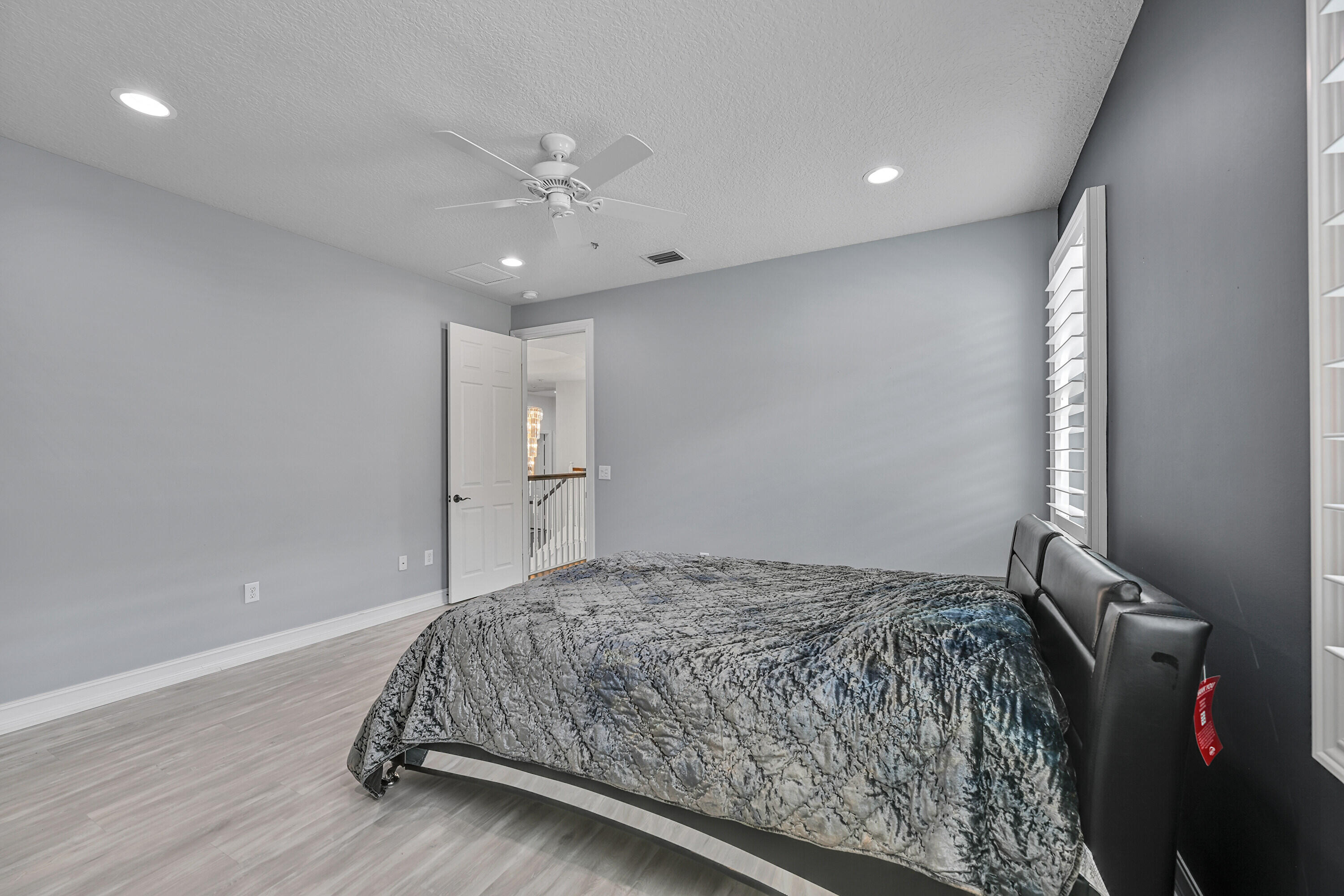 8652 Lewis River Road Delray Beach, FL 33446 - Photo 63 of 85 a bedroom with a large bed and a chandelier