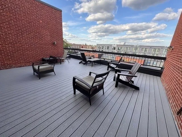 a roof deck with couches and wooden floor