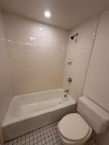 a white toilet and tub sitting next to a bathroom sink