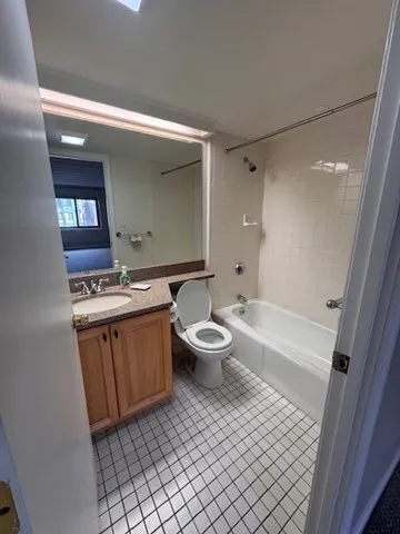 a bathroom with a granite countertop toilet a sink and a bathtub