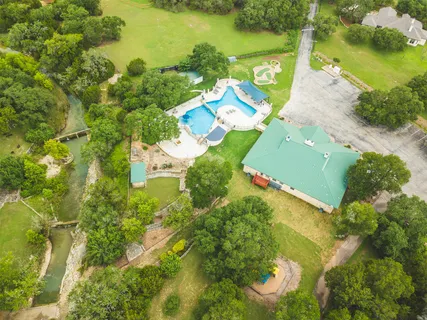an aerial view of a houses with swimming pool
