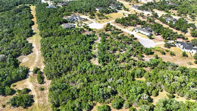 an aerial view of residential house with green space and trees all around