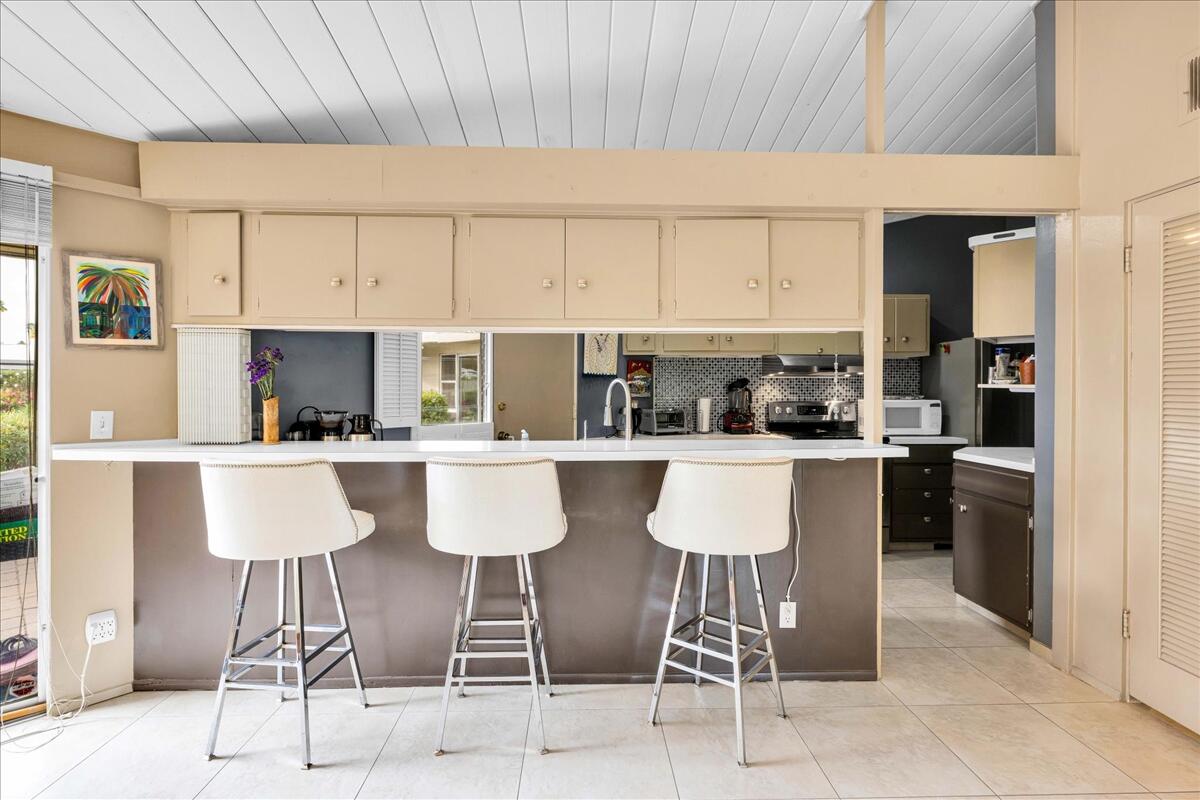 37800 Da Vall Drive, Unit 1 Rancho Mirage, CA 92270 - Photo 12 of 36 a kitchen with stainless steel appliances kitchen island granite countertop a table and chairs in it
