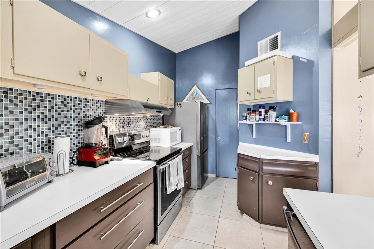 37800 Da Vall Drive, Unit 1 Rancho Mirage, CA 92270 - Photo 14 of 36 a kitchen with stainless steel appliances a sink stove and cabinets